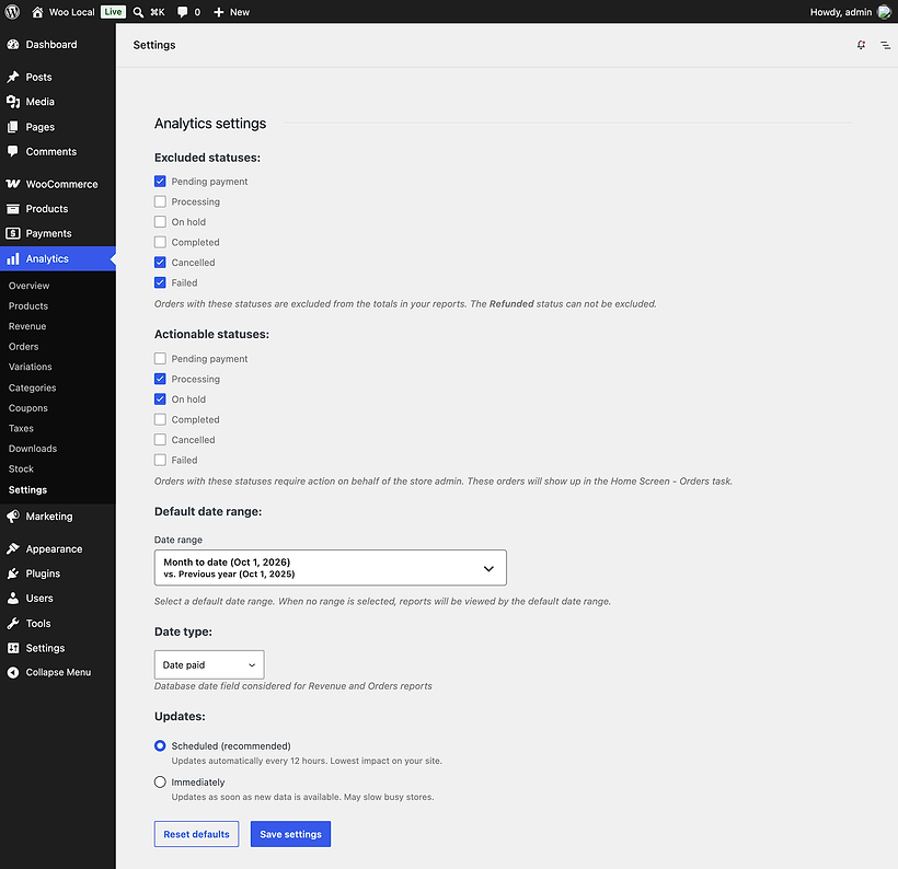 The WooCommerce 11.1.2 Analytics settings page: Excluded statuses with Pending payment, Cancelled and Failed ticked and a note that the Refunded status can not be excluded, Actionable statuses with Processing and On hold ticked, a default date range, Date type set to Date paid, and Updates with Scheduled (recommended) selected next to Immediately.